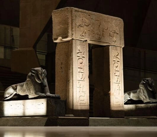 Rzeźby dwóch sfinksów flankujących kamienny portal z inskrypcjami w centralnym holu muzeum.