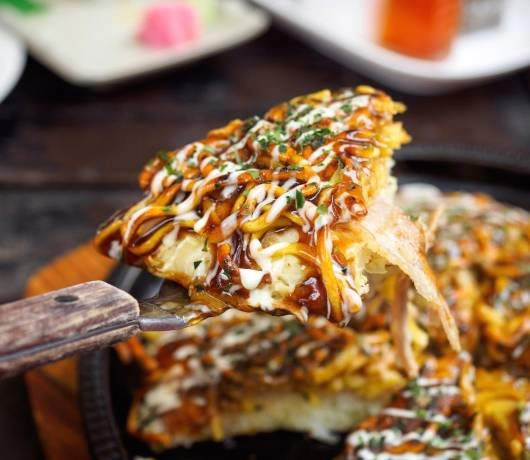 Okonomiyaki, czyli placki z kapustą i różnym składnikami polane słodkim sosem