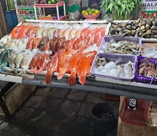 Stragan z rybami i owocami morza na targu w Labuan Bajo.
