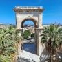 Dawna kopalnia Porto Flavia Monumentalny łuk Bastione di Saint Remy w Cagliari otoczony palmami i kamiennymi schodami. w stromym klifie nad turkusowym morzem na Sardynii.