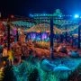 Artystyczna strefa relaksu nocą w Bielsku-Białej, z piaskiem, siedziskami, świetlną instalacją i uczestnikami wydarzenia.