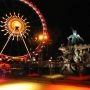 Diabelskie koło i lodowisko nocą na Alexanderplatz w Berlinie, oświetlone świątecznymi dekoracjami.