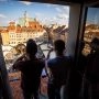 Muzycy Brass Federacji grają na instrumentach dętych w oknie kamienicy z widokiem na Rynek Starego Miasta w Warszawie.