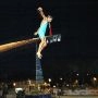 Uczestnik Palio della Cuccagna stoi na końcu natłuszczonego masztu zawieszonego nad wodą w Cesenatico.