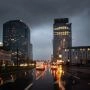 Nocny widok Warszawy po deszczu, biurowce i światła samochodów odbijające się w ulicy