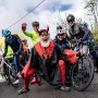 Kolarze stoją na starcie wydarzenia L’Étape Poland by Tour de France, obok nich maskotka Tour de France pozuje do zdjęcia.