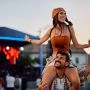 Uśmiechnięta para bawi się podczas letniego festiwalu plenerowego przy scenie koncertowej.