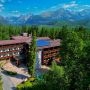 Hotel Borovica położony wśród lasów Štrbskiego Plesa na tle panoramy Tatr Wysokich.