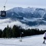 Narciarze na trasie zjazdowej w ośrodku Bachledka Ski & Sun z widokiem na Tatry.