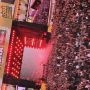 Artysta występujący na czerwono oświetlonej scenie Łódź Summer Festival przed tłumem publiczności.