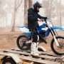 Mężczyzna siedzący na motorze z przyczepka motocyklową