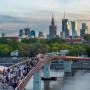 Kładka pieszo-rowerowa nad Wisłą w Warszawie z dużą liczbą spacerujących osób.