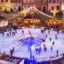 Widok z góry na oświetlone lodowisko na Rynku Starego Miasta w Warszawie, z licznymi łyżwiarzami i świątecznymi światłami.