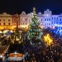 Tłum ludzi zgromadzonych wokół wielkiej udekorowanej choinki i świątecznych straganów na Placu Perštýnskim w Pardubicach.