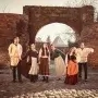 Zespół Muzeum Historii Partaczy w Toruniu w historycznych strojach przy gotyckiej bramie toruńskiej starówki