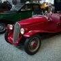 Czerwony zabytkowy samochód sportowy z lat 20. XX wieku na ekspozycji Narodowego Muzeum Motoryzacji w Miluzie, prezentowany wśród klasycznych europejskich modeli.