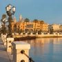 Nadmorska promenada w Bari z ławkami, palmami i zabytkową zabudową miasta, z latarnia na przodzie