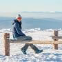 Turystka odpoczywająca na ławce na ośnieżonym szlaku w Masywie Śnieżnika.