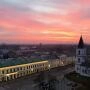 Centrum Suwałk widziane z góry o zachodzie słońca, z zabytkową zabudową, kościołem i różowym niebem nad miastem.