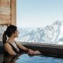 Kobieta w górskim basenie w Rifugio Capanna Presena, patrząca na ośnieżone szczyty masywu Adamello w Trentino.