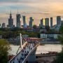 Kładka pieszo-rowerowa nad Wisłą w Warszawie, spacerujący ludzie i panorama miasta.