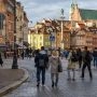 pacerowicze na Starym Mieście w Warszawie, w tle kolorowe kamienice i kościół św. Anny