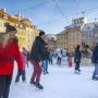 Ludzie jeżdżący na łyżwach na lodowisku w centrum Warszawy zimą.