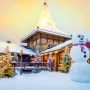 Drewniany dom w Santa Claus Village w Rovaniemi, ośnieżone choinki i ogromny bałwan przed wejściem.