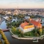 Widok z góry na wyspę otoczoną ramionami Odry, zabytkowy kościół, czerwone dachy, mosty i centrum Wrocławia.