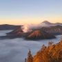 Wulkan Bromo o świcie, otoczony morzem chmur i dymem unoszącym się z krateru, widziany z punktu widokowego w Tengger.