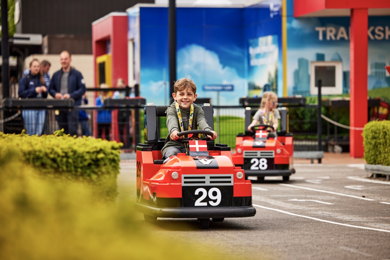 Dziecko prowadzi mały czerwony samochód na torze w Legolandzie w Billund