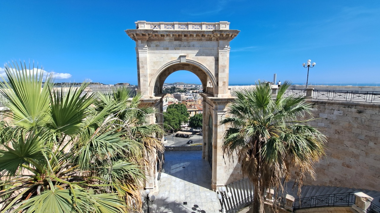 Dawna kopalnia Porto Flavia Monumentalny łuk Bastione di Saint Remy w Cagliari otoczony palmami i kamiennymi schodami. w stromym klifie nad turkusowym morzem na Sardynii.