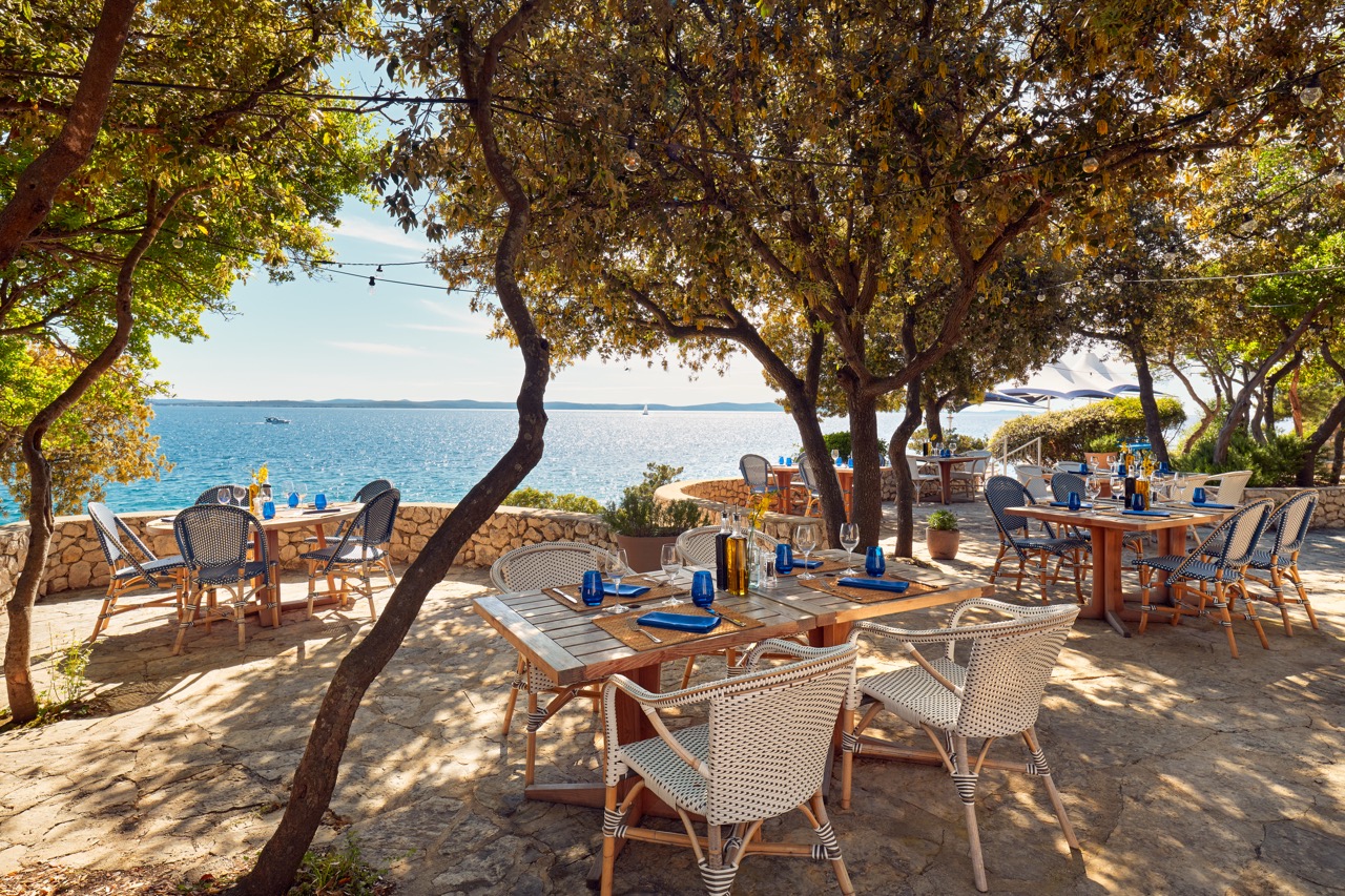 Stoliki ustawione w restauracji nad samym morzem w Punta Skala nakryte do obiadu