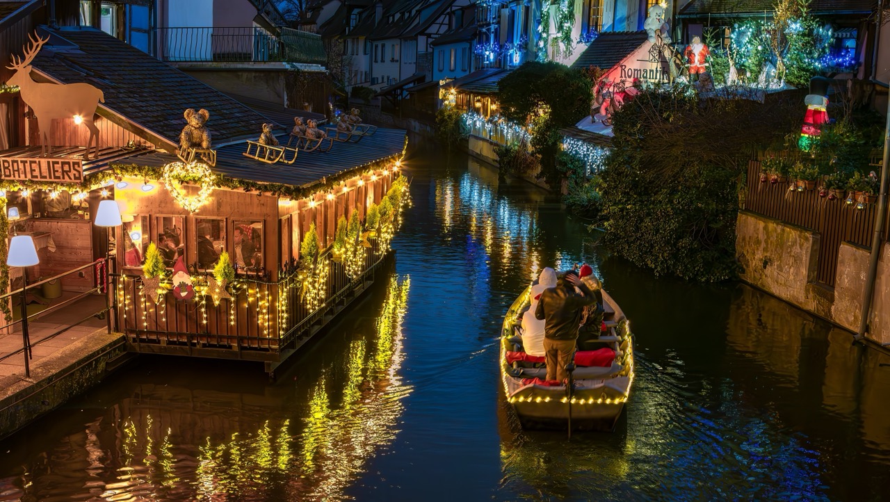 Colmar w czasie świąt, zabudowa nad kanałem Petite Venise z delikatnymi iluminacjami bożonarodzeniowymi.