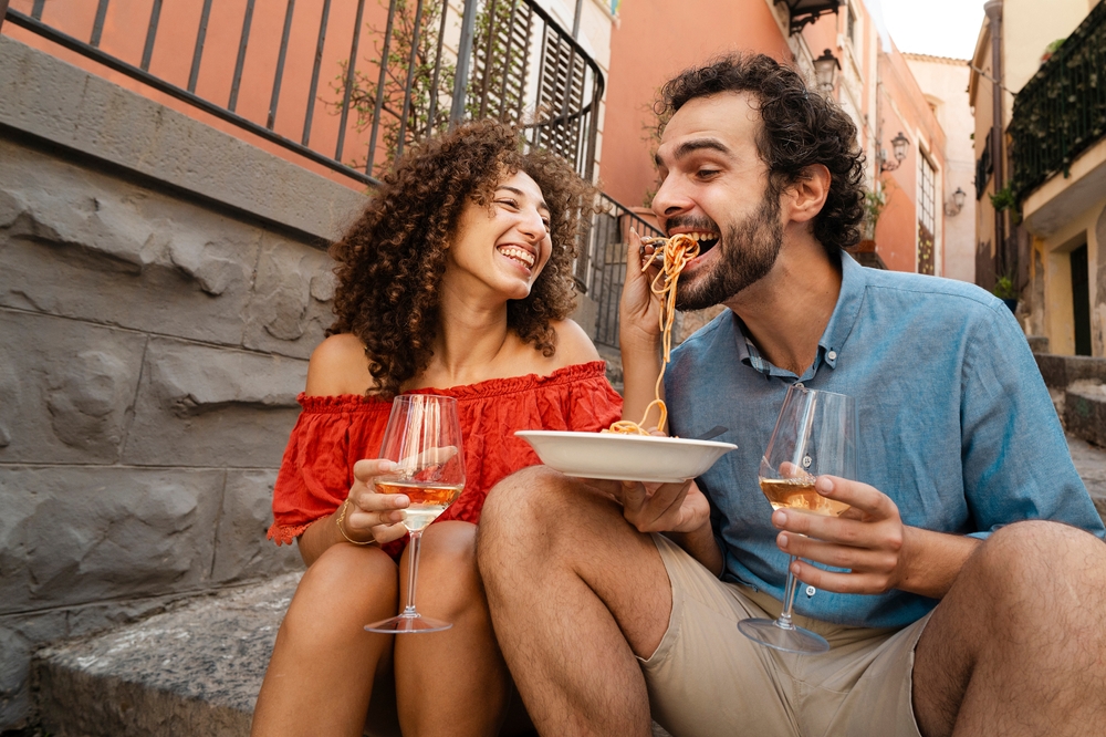 Włoska kolacja na starówce para jedząca makaron i pijąca wino