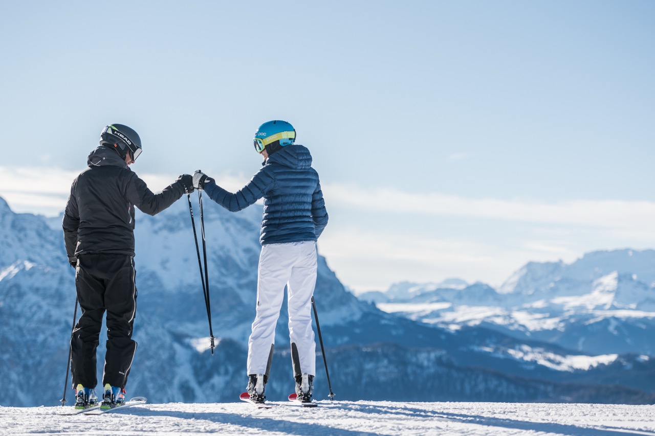 Narciarze podziwiający panoramę Dolomitów na szczycie Plan de Corones