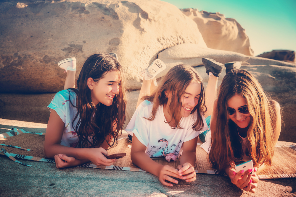 Trzy dziewczyny odpoczywające na skałach nad morzem podczas wakacji w Grecji
