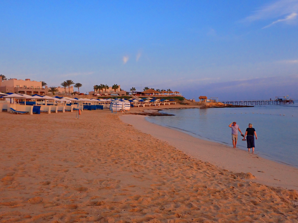 Piaszczysta plaża w Marsa Alam nad Morzem Czerwonym, parasole plażowe i spokojna linia brzegowa