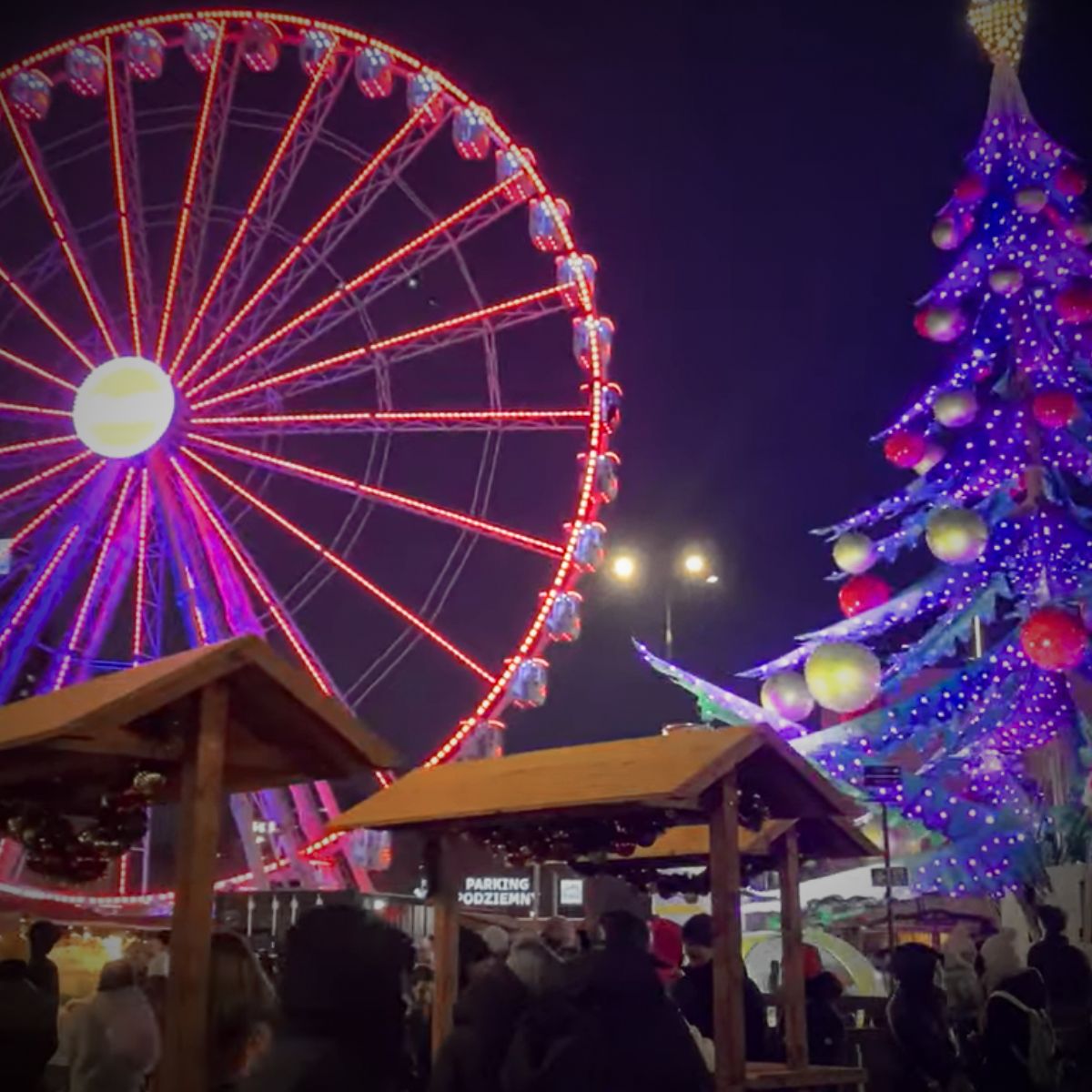 Diabelski młyn i kolorowa świąteczna choinka oświetlone nocą na Jarmarku Warszawskim.