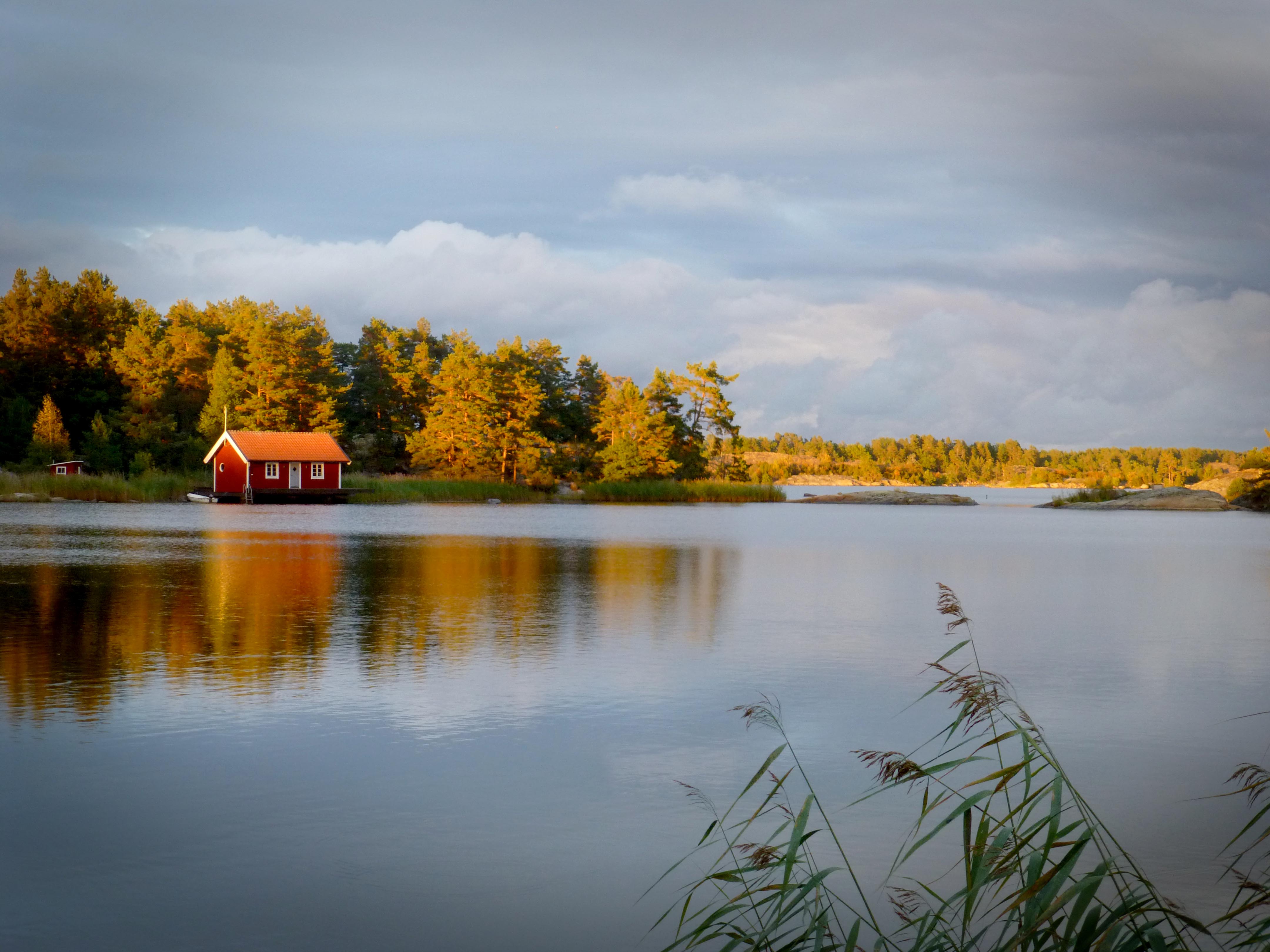 Czerwony drewniany domek nad wodą na jednej z wysp szwedzkiego archipelagu.