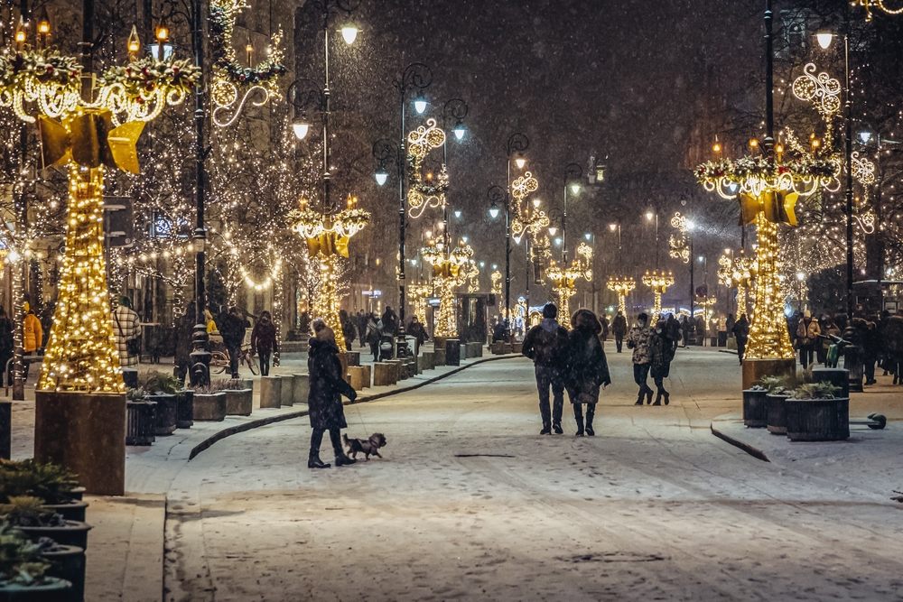 Oświetlone latarnie i dekoracje świąteczne na Krakowskim Przedmieściu zimą.