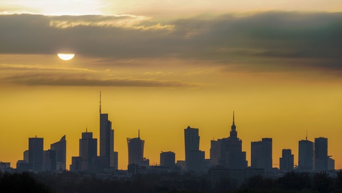 Panorama Warszawy o zachodzie słońca z widokiem na centrum miasta.