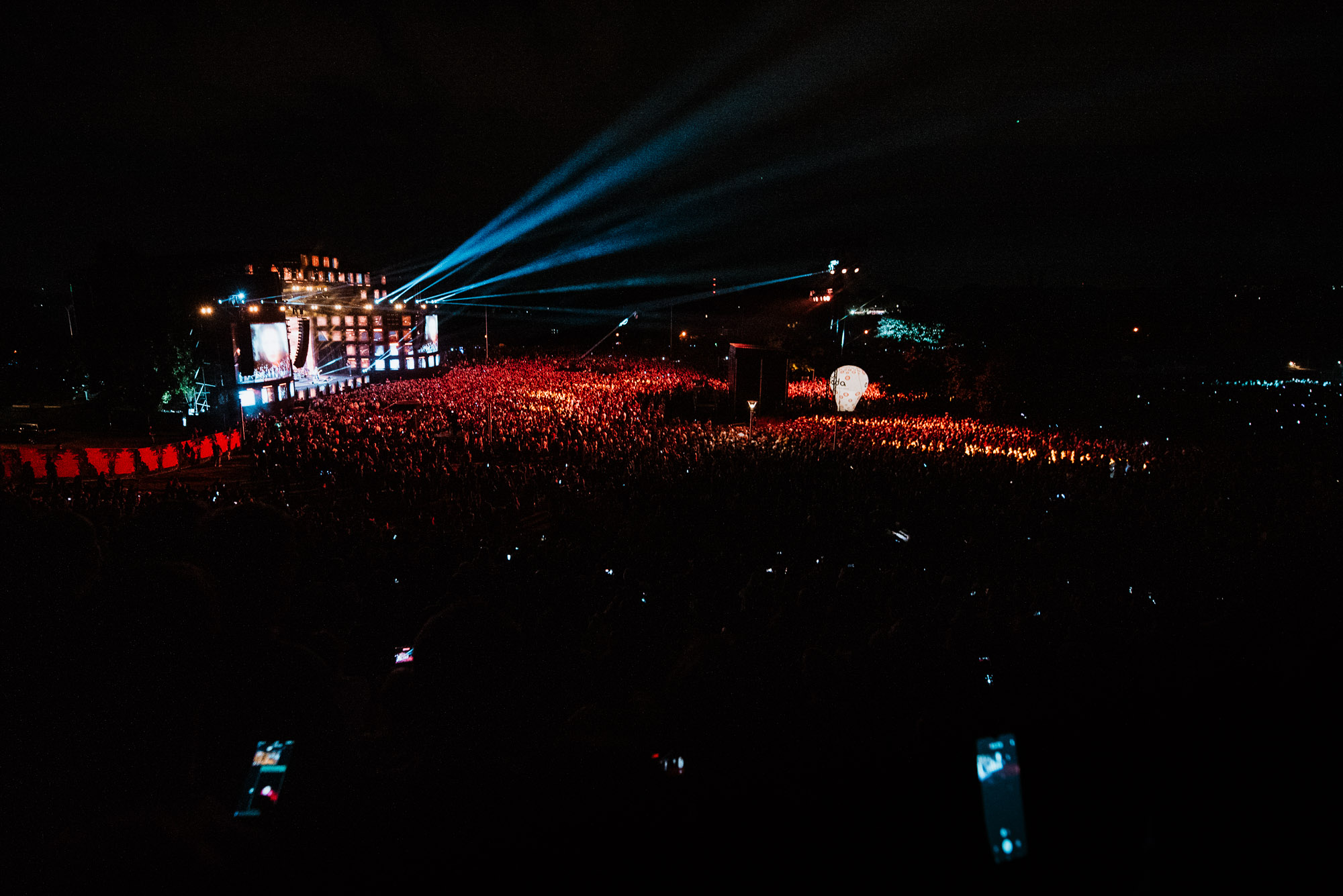 Koncert Wianki nad Wisłą w Warszawie, tłum publiczności i scena z reflektorami po zmroku.