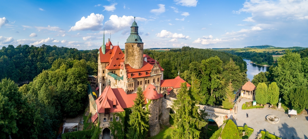Widok z lotu ptaka na Zamek Czocha położony nad Jeziorem Leśniańskim i otoczony lasami.